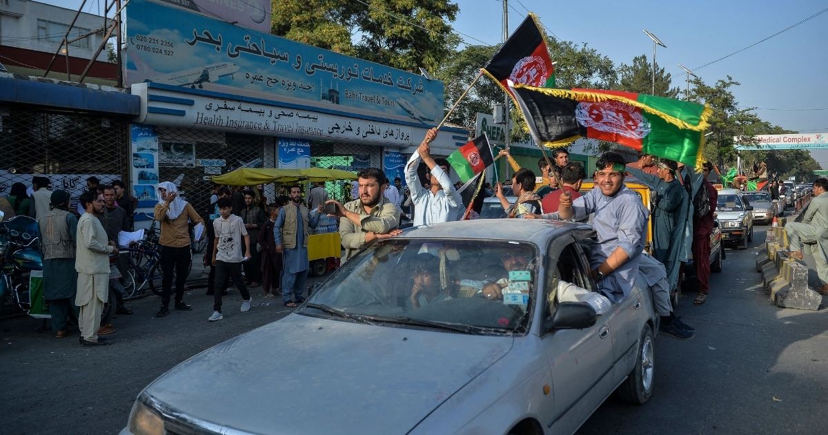 People carry Afghanistan's national flag on the 102th Independence Day of the country in the Wazi Akbar khan area of Kabul on Thursday amid the Taliban's military takeover of Afghanistan.