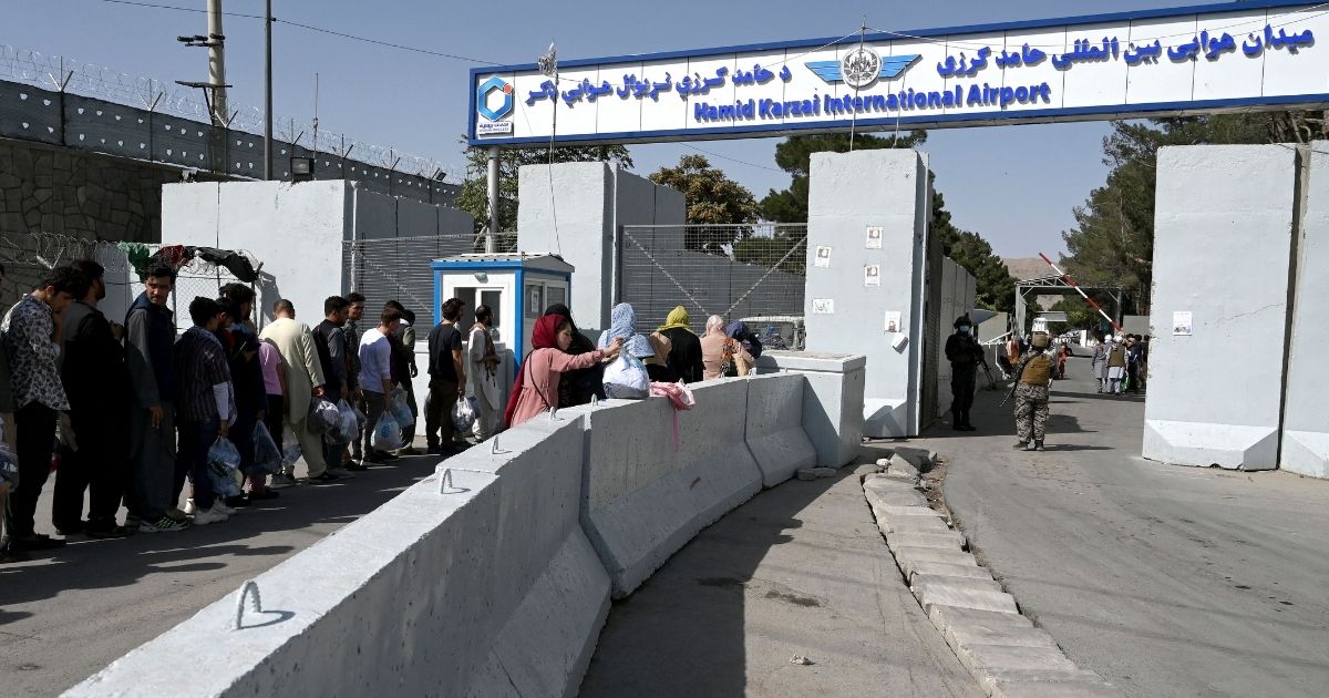 Afghans line up at the main entrance gate of the Kabul airport on Saturday in Afghanistan.