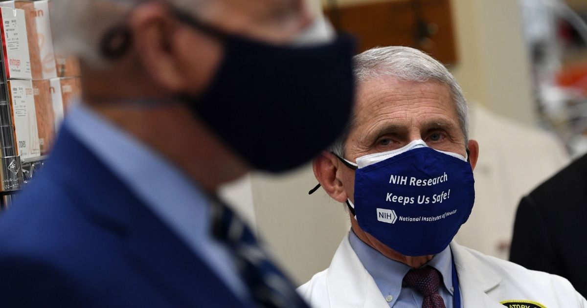White House Chief Medical Adviser on COVID-19 Dr. Anthony Fauci, right, looks on as President Joe Biden tours the Viral Pathogenesis Laboratory at the National Institutes of Health (NIH) in Bethesda, Maryland, on Feb. 11, 2021.