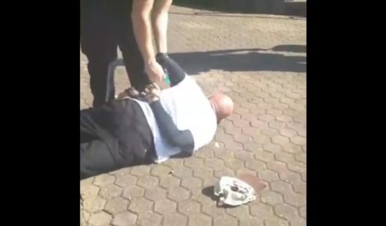 A man in Brisbane, Australia, is seen experiencing a medical emergency after being arrested, reportedly for not wearing a mask.