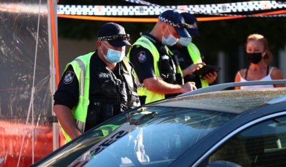Queensland Police stop cars at the state's border on Wednesday in Coolangatta, Australia, to check drivers' vaccination status.