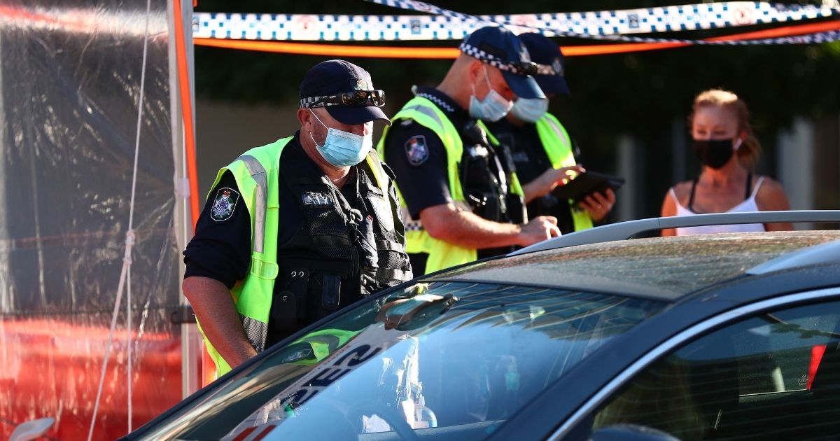 Queensland Police stop cars at the state's border on Wednesday in Coolangatta, Australia, to check drivers' vaccination status.