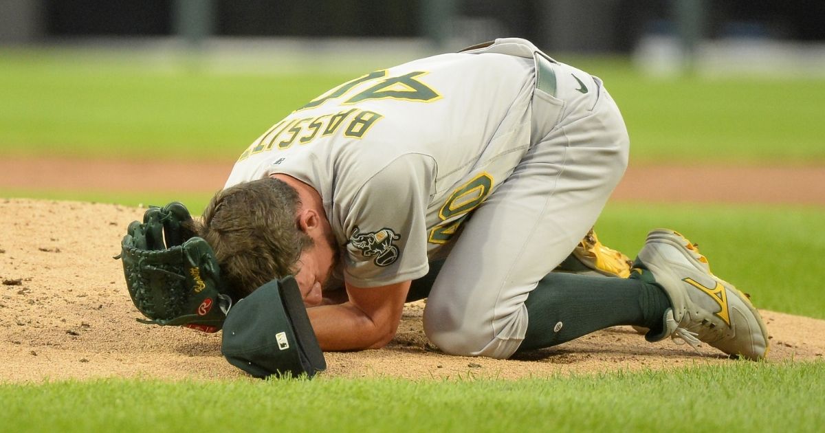 Chris Bassitt of the Oakland Athletics lies on the ground after being hit in the face by a line drive in the second inning of a game against the Chicago White Sox on Tuesday at Guaranteed Rate Field.