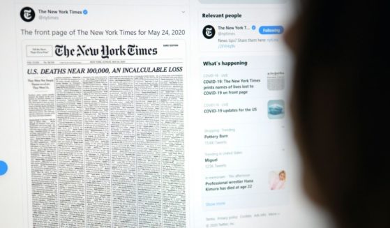 This picture taken on May 23, 2020, in Los Angeles shows a woman looking at a computer screen with a tweet by the New York Times newspaper account showing the early edition front page of May 24, 2020, with a list of 1,000 names printed on it, that represents 1 percent of the lives lost due to the novel coronavirus pandemic, COVID-19, in the U.S.