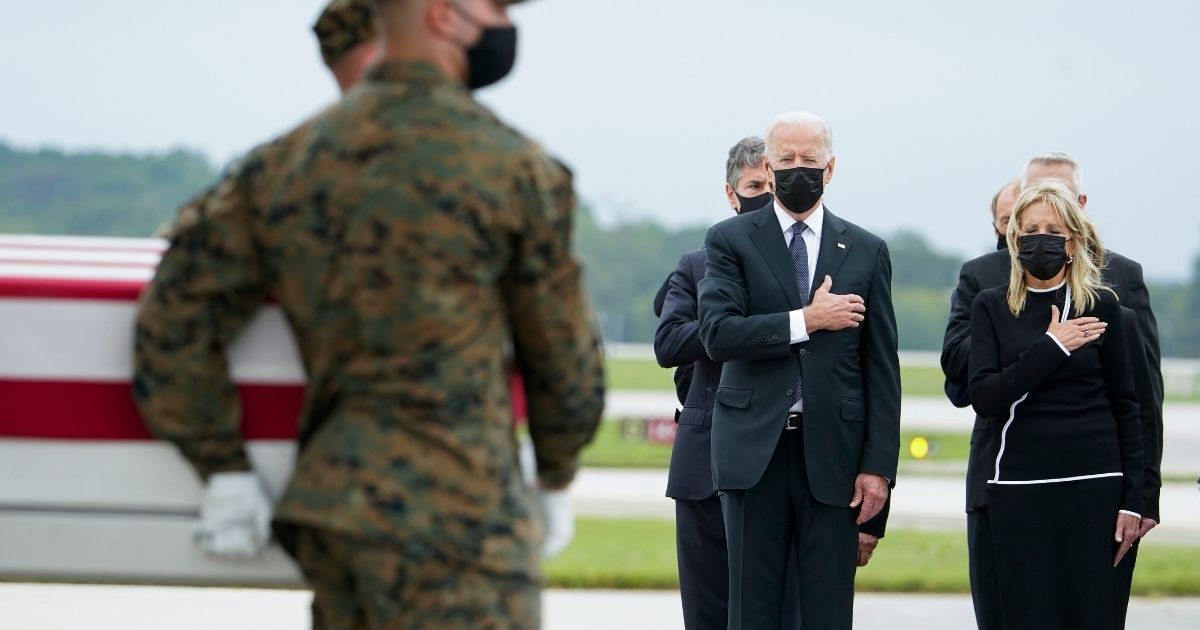 President Joe Biden and first lady Jill Biden watch as a Marine Corps carry team moves a transfer case containing the remains of Marine Corps Sgt. Johanny Rosario Pichardo, 25, of Lawrence, Massachusetts, on Sunday at Dover Air Force Base, Delaware.
