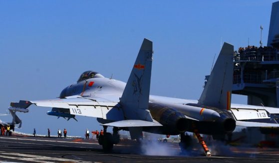 A Chinese J15 Jet takes off from an aircraft carrier in the China Sea during a military drill.