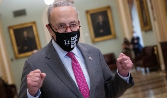 Senate Majority Leader Chuck Schumer raises his fists as he emerges from the Senate chamber after the final passage of the $1.2 trillion "infrastructure" bill at the Capitol in Washington on Tuesday.