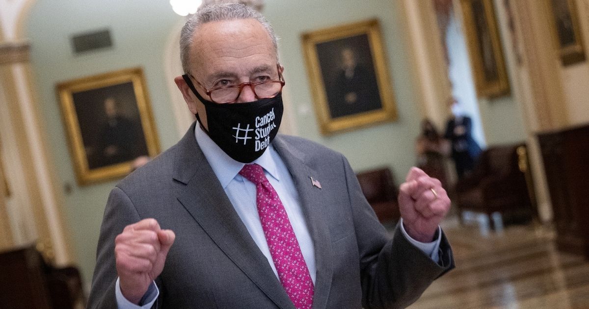 Senate Majority Leader Chuck Schumer raises his fists as he emerges from the Senate chamber after the final passage of the $1.2 trillion "infrastructure" bill at the Capitol in Washington on Tuesday.