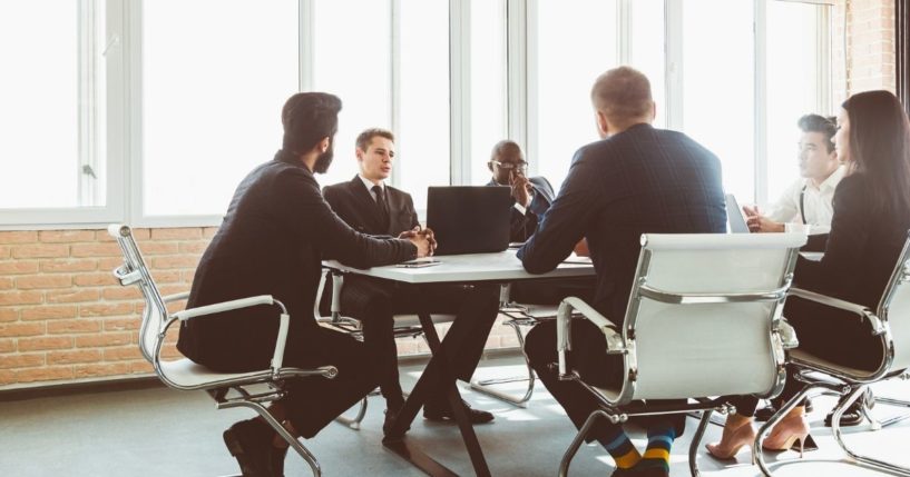 Members of a corporate board are shown in a meeting in the stock image above.