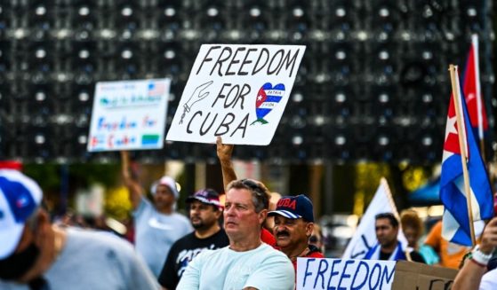 People hold freedom signs during a rally in Miami calling for freedom in Cuba, Venezuela and Nicaragua on Saturday.