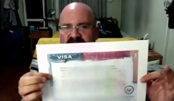 David Fox, an American in Kabul, Afghanistan, holds up what he says is a blank visa form distributed by the State Department.