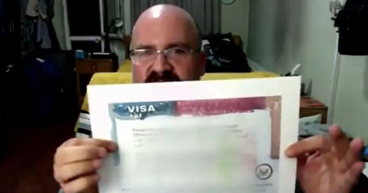 David Fox, an American in Kabul, Afghanistan, holds up what he says is a blank visa form distributed by the State Department.