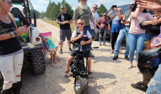 Wyatt Dennis, an 8-year-old from South Dakota who ran a lemonade stand to raise money for college and charity, tests out the dirt bike he was gifted.