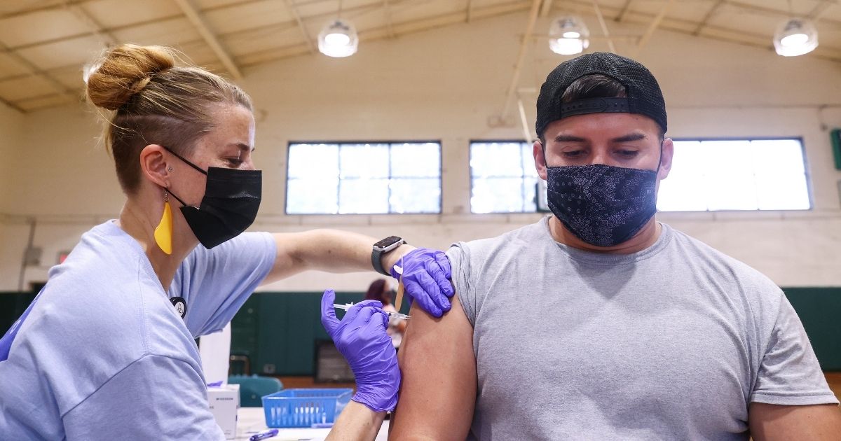 Nurse practitioner Dawn Kaiser administers a COVID-19 vaccination dose to a person at a clinic operated by DePaul Community Health Center at Isidore Newman School on August 13, 2021, in New Orleans.