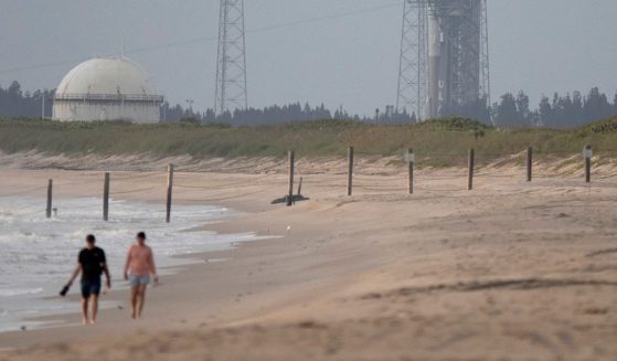People walk along the beach near the Cape Canaveral Space Force Station on Aug. 3, 2021, in Cape Canaveral, Florida.