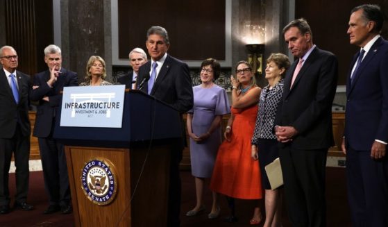 Democratic Sen. Joe Manchin of West Virginia speaks about the bipartisan infrastructure package while his fellow negotiators -- from left, Sens. Kevin Cramer of North Dakota, Bill Cassidy of Louisiana, Lisa Murkowski of Alaska, Rob Portman of Ohio, Susan Collins of Maine, Kyrsten Sinema of Arizona, Jeanne Shaheen of New Hampshire, Mark Warner of Virginia and Mitt Romney of Utah -- listen during a news conference at the Dirksen Senate Office Building on Capitol Hill in Washington on July 28.