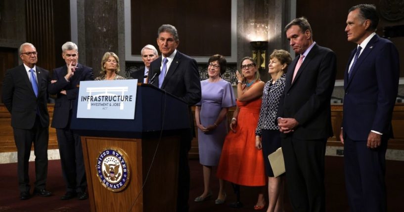 Democratic Sen. Joe Manchin of West Virginia speaks about the bipartisan infrastructure package while his fellow negotiators -- from left, Sens. Kevin Cramer of North Dakota, Bill Cassidy of Louisiana, Lisa Murkowski of Alaska, Rob Portman of Ohio, Susan Collins of Maine, Kyrsten Sinema of Arizona, Jeanne Shaheen of New Hampshire, Mark Warner of Virginia and Mitt Romney of Utah -- listen during a news conference at the Dirksen Senate Office Building on Capitol Hill in Washington on July 28.