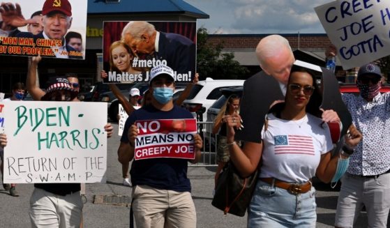 Protesters hold anti-Biden signs as they walk by the Democratic National Convention site at the Chase Center in Wilmington, Delaware, on Aug. 20, 2020.