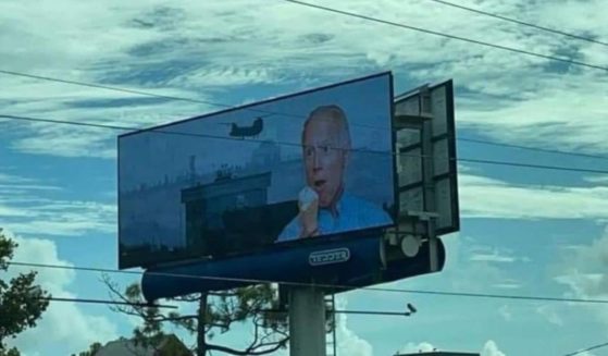 A billboard in Wilmington, North Carolina, depicts President Joe Biden eating an ice cream cone, as the evacuation of Afghanistan goes on in the background.