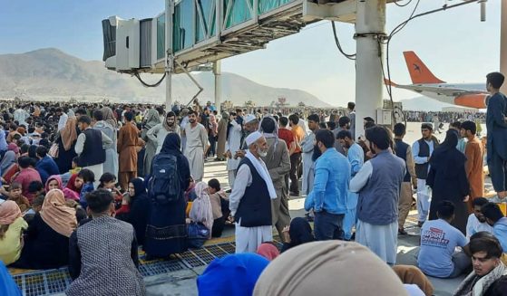 People crowd the tarmac of the Kabul airport on Monday to flee the country as the Taliban takes control of Afghanistan.