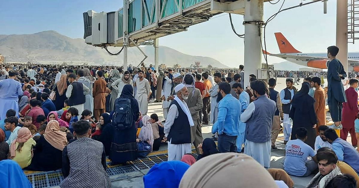 People crowd the tarmac of the Kabul airport on Monday to flee the country as the Taliban takes control of Afghanistan.