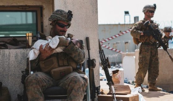 A U.S. Marine is pictured holding an infant at Hamid Karzai International Airport in Kabul, Afghanistan.