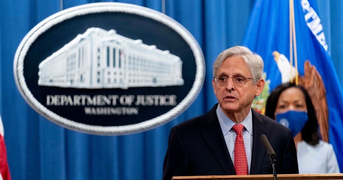 Attorney General Merrick Garland, accompanied by Assistant Attorney General for Civil Rights Kristen Clarke, right, speaks at a news conference at the Department of Justice in Washington on Thursday.