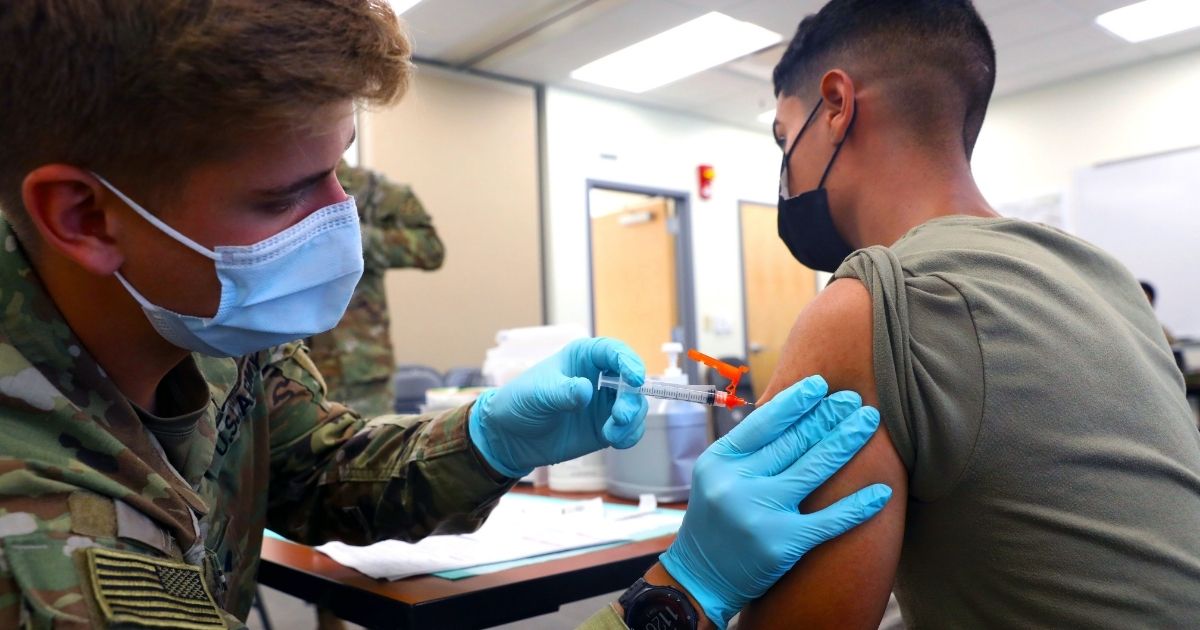 Army Spc. Tyler Boyer administers the COVID-19 vaccine to another soldier at Fort Carson, Colorado, on Tuesday.