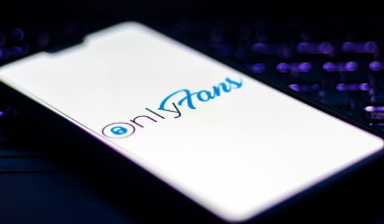The logo of the website OnlyFans is displayed on a cellphone screen in this stock image.