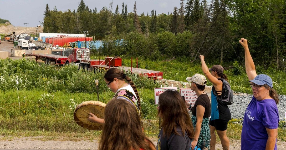 Activists raise their fists as they pass sections of the Enbridge Line 3 pipeline construction during the 'Treaty People Walk for Water' event near the La Salle Lake State Park in Solway, Minnesota, on Saturday.