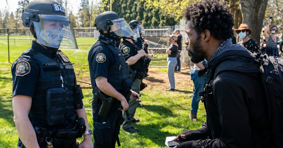 A protester yells at a Portland, Oregon, officer after a fatal police shooting in the city's Lents Park on April 16.
