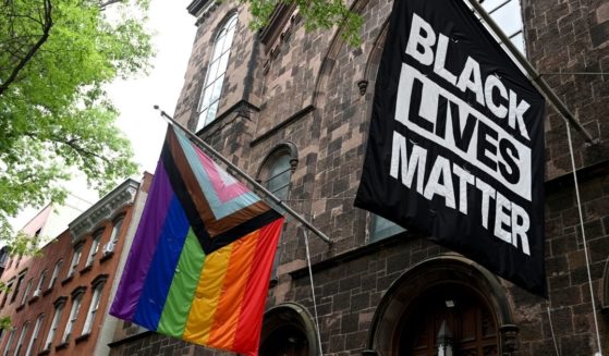 A progress pride flag and a Black Lives Matter flag are displayed outside a church on June 13, 2021, in the Brooklyn borough of New York City.