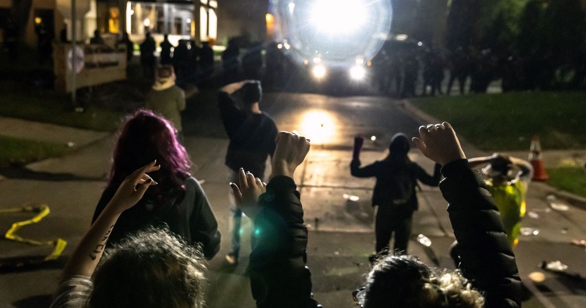 Protesters face off against a line of police officers at the Brooklyn Center Police Station in Minneapolis on April 11, 2021.
