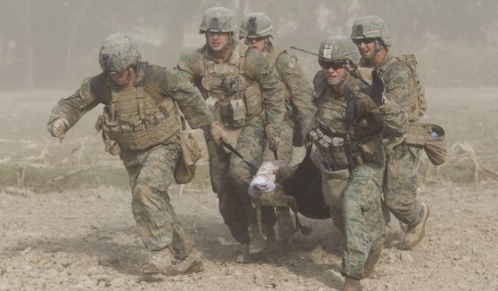U.S. Marines, through a haze of fine dust kicked up by the helicopter's rotor blades, carry a wounded comrade who was hit by an Improvised Explosive Device (IED) to a medevac helicopter in the Helmand province of Afghanistan on Nov. 2, 2011.