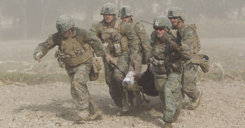 U.S. Marines, through a haze of fine dust kicked up by the helicopter's rotor blades, carry a wounded comrade who was hit by an Improvised Explosive Device (IED) to a medevac helicopter in the Helmand province of Afghanistan on Nov. 2, 2011.