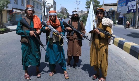 Taliban fighters stand guard along a road in Herat on Thursday amid the Taliban's military takeover of Afghanistan.