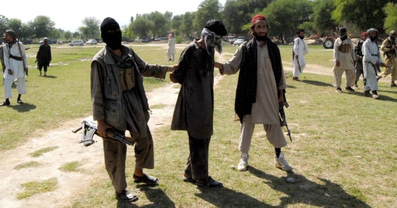 Pakistani Taliban escort a kidnapper, center, as they arrive for his execution at the Rahim Kor village near the Mammad agency, some 60 kilometers from Peshawar, on April 27, 2008.