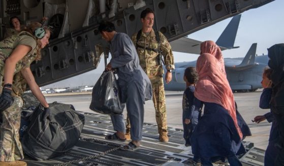 In this handout provided by U.S. Central Command Public Affairs, U.S. Air Force loadmasters and pilots assigned to the 816th Expeditionary Airlift Squadron load passengers aboard a U.S. Air Force C-17 Globemaster III in support of the Afghanistan evacuation at Hamid Karzai International Airport on Tuesday in Kabul, Afghanistan.