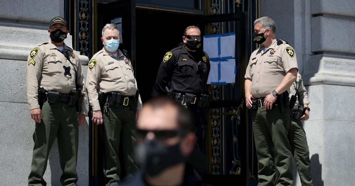 San Francisco sheriff's deputies monitor a protest against California Gov. Gavin Newsom's continued statewide shelter-in-place order outside of San Francisco City Hall on May 01, 2020.