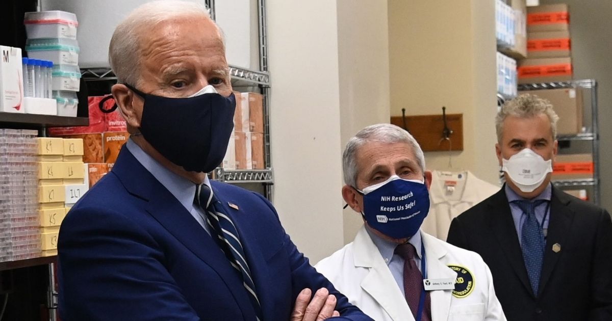 Double-masked President Joe Biden and White House coronavirus adviser Dr. Anthony Fauci take part in a February tour of the Viral Pathogenesis Laboratory at the National Institutes of Health in Bethesda, Maryland.