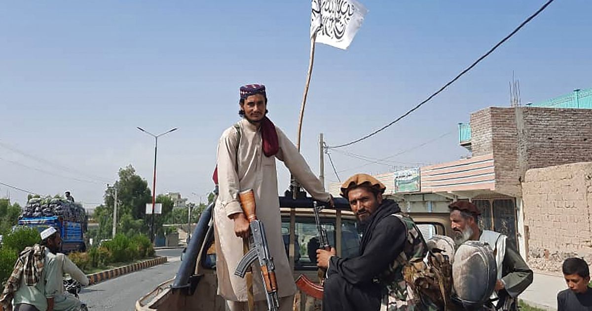 Taliban fighters ride aboard a captured Afghan National Army vehicle through the streets of Laghman province in Afghanistan on Sunday.