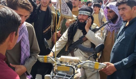 Taliban fighters mingle with civilians in the Afghan city of Pul-e- Khumm, about 100 miles north of Kabul last week.