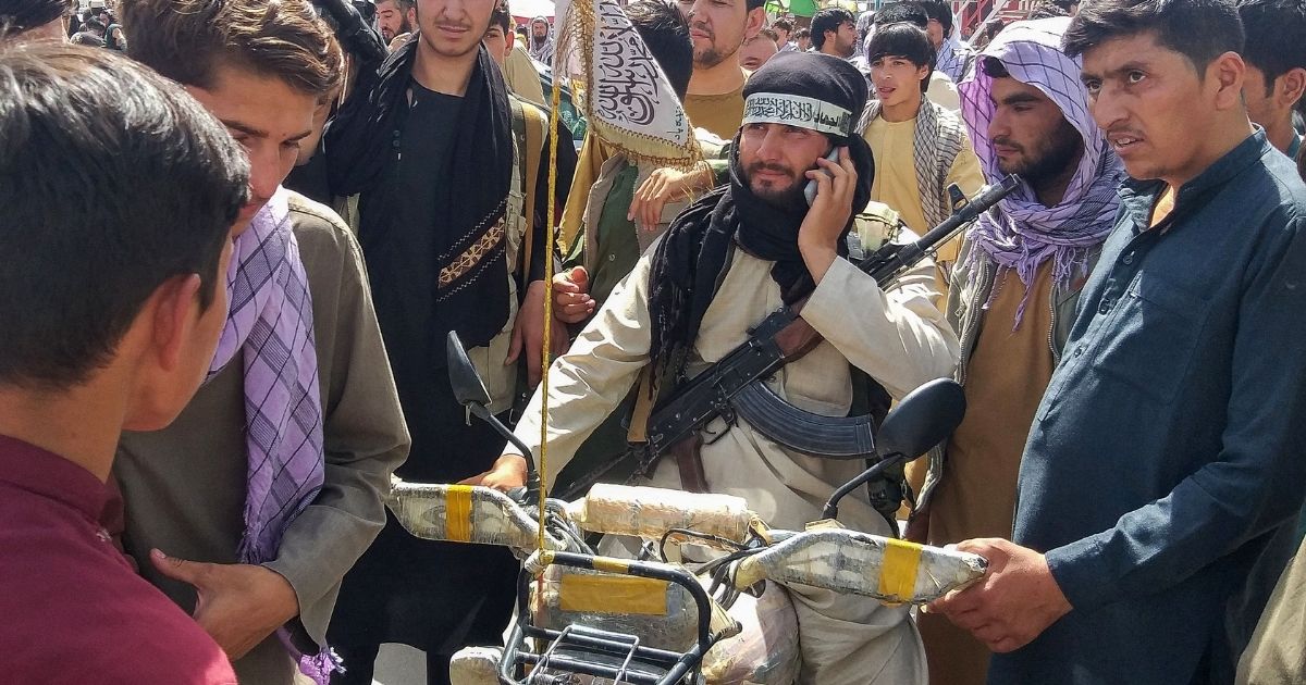 Taliban fighters mingle with civilians in the Afghan city of Pul-e- Khumm, about 100 miles north of Kabul last week.