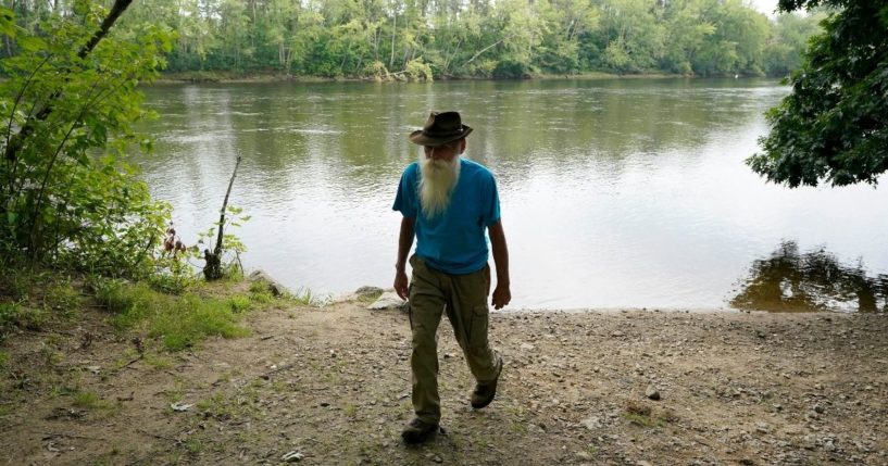 David Lidstone, 81, walks along a path away from the Merrimack River in New Hampshire on Aug. 10, 2021. Lidstone is an off-the-grid hermit known to locals as 'River Dave.'