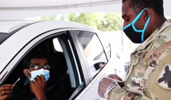 A Louisiana Army National Guard soldier waits to collect a swab from a driver at a COVID-19 drive-through testing site operated by the Guard on Aug. 11, 2021, in New Orleans. In Mississippi, one official says his state is in 'as bad of a situation as we can be.'