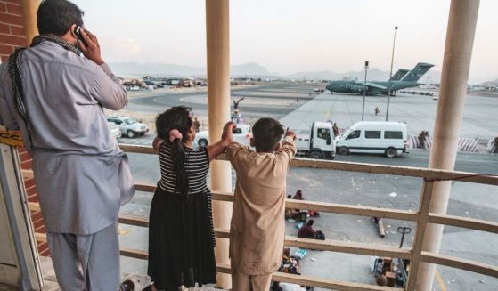 In a handout provided by the U.S. Marine Corps, an Afghan family looks over Hamid Karzai International Airport during the evacuation from Kabul on Saturday.