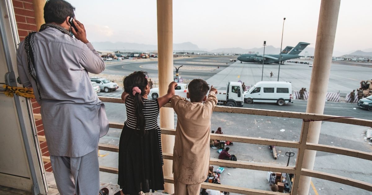 In a handout provided by the U.S. Marine Corps, an Afghan family looks over Hamid Karzai International Airport during the evacuation from Kabul on Saturday.