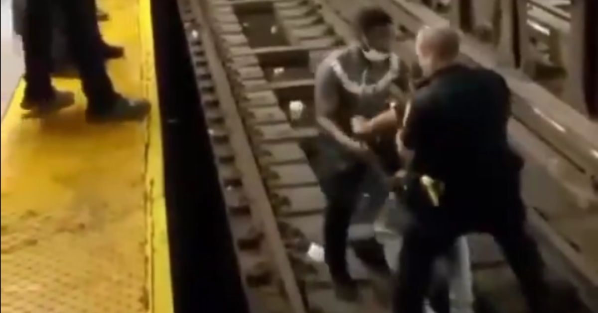 An NYPD officer and a Good Samaritan pick up an ill man from a subway track in New York City before carrying him to safety on Aug. 19, 2021.
