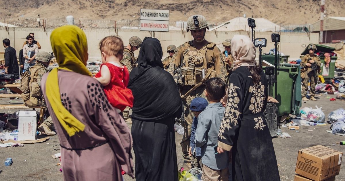 In an image provided by the U.S. Marine Corps, Marines process evacuees Hamid Karzai International Airport in Kabul, Afghanistan, on Saturday.