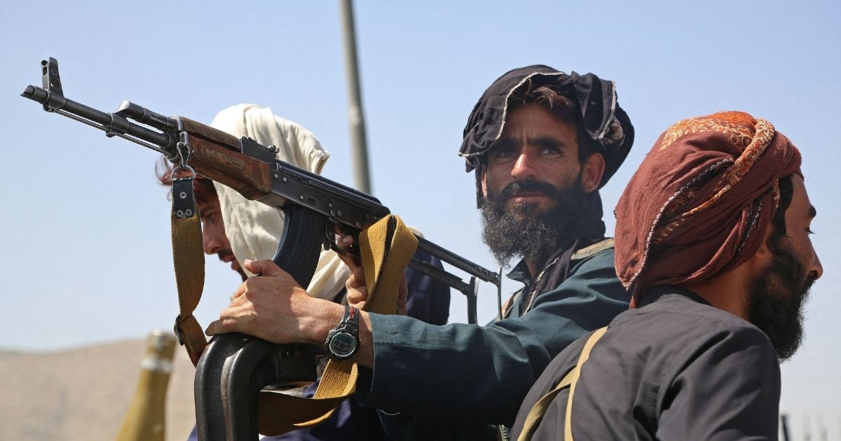 On Monday, Taliban fighters stand on a vehicle at the roadside in Kabul.